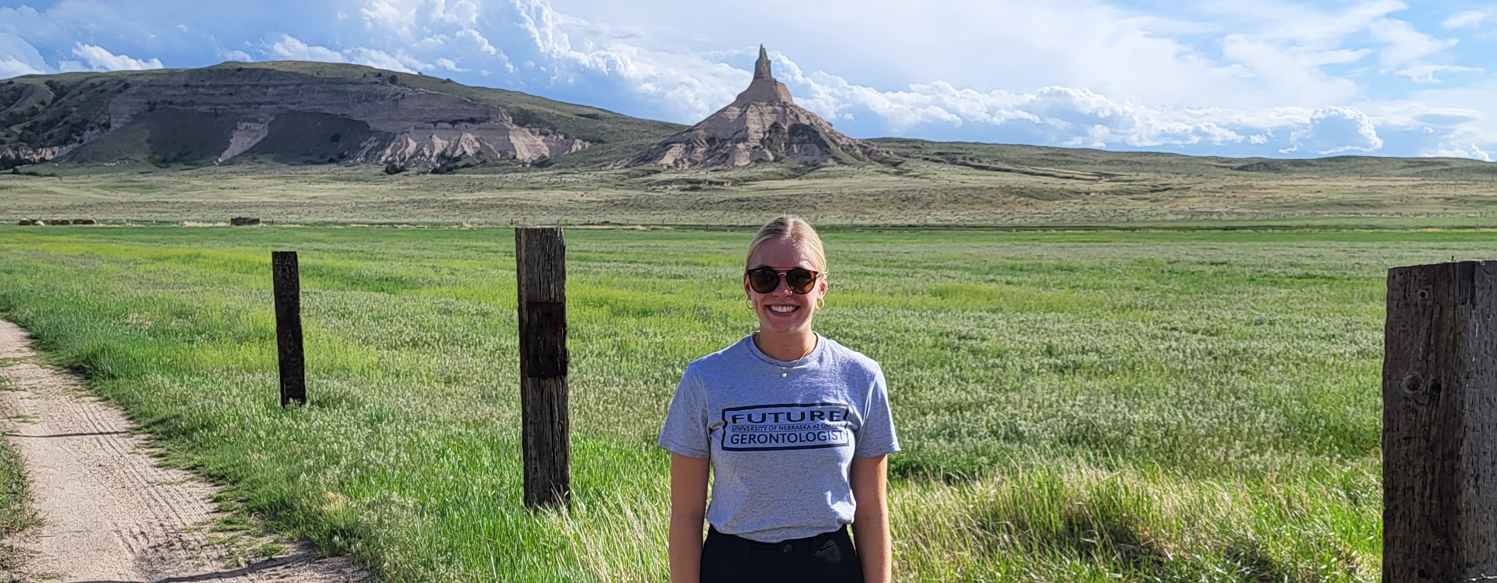 Student wearing Future Gerontologist t-shirt in front of Chimney Rock