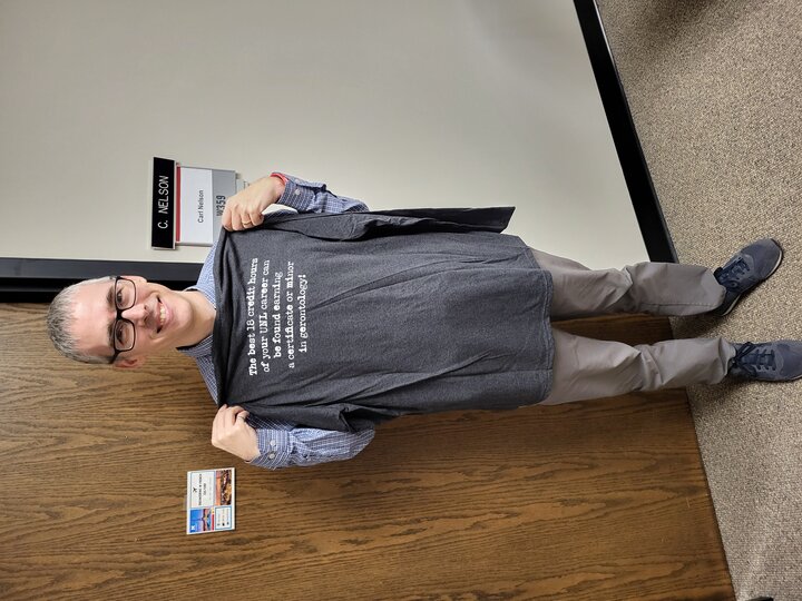 Dr. Carl Nelson holding a t-shirt