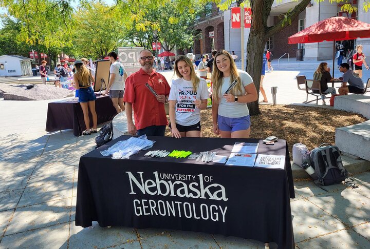 Gerontology students behind a table with swag items